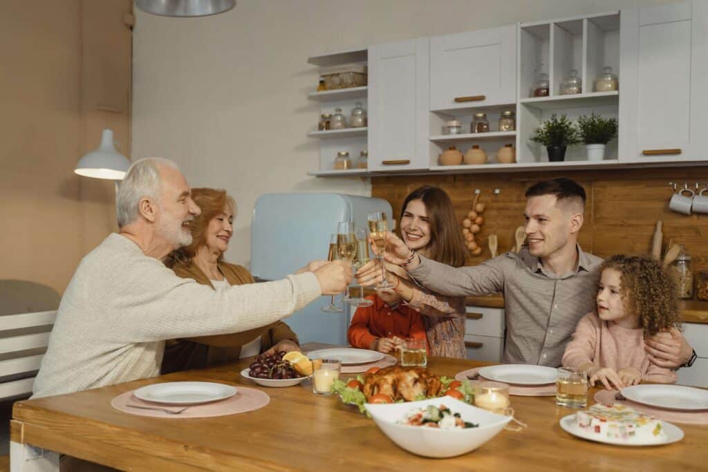 A happy family enjoying dinner together in a well-lit, open kitchen that blends timeless design and functionality