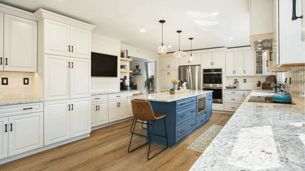 Modern kitchen remodel with white shaker cabinets, blue island, granite countertops, stainless steel appliances, and hardwood flooring