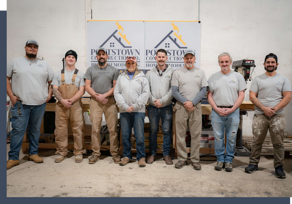 Pottstown Construction Company team members standing together in front of branded signage on job site