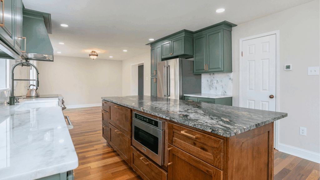 Modern kitchen remodel with green custom cabinets, granite countertops, and stainless steel appliances by Pottstown Construction Company