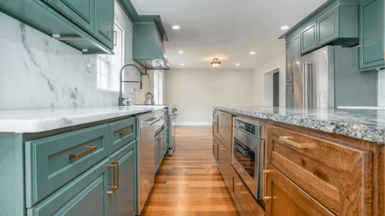 Modern kitchen remodel with teal cabinets, marble backsplash, granite countertops, and wood flooring