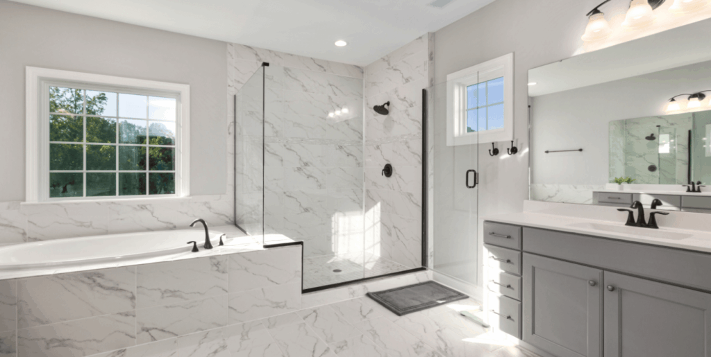 Luxury bathroom remodel with marble tile, frameless glass shower enclosure, soaking tub, and dual vanity
