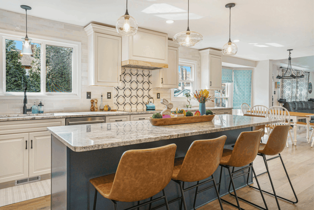 Modern kitchen remodel with cream cabinets, granite countertops, island seating, and pendant lighting