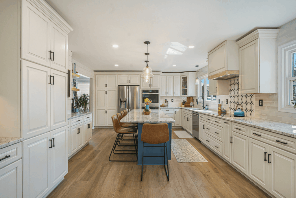 Modern kitchen remodel with cream cabinetry, granite countertops, stainless steel appliances, and hardwood flooring