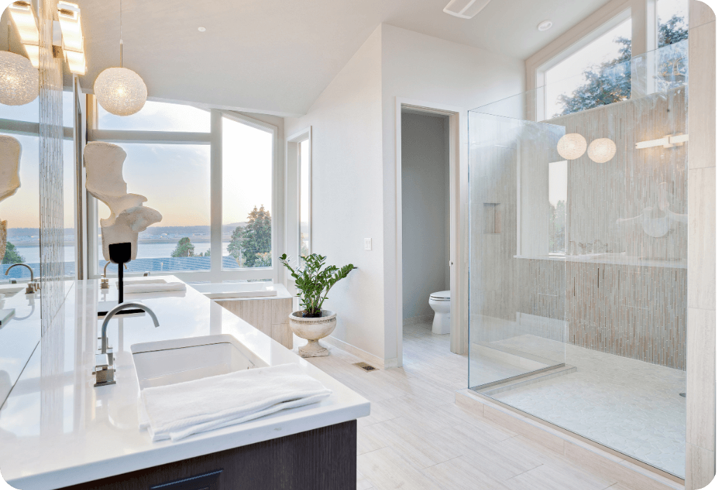 Modern luxury bathroom remodel with white quartz countertops, glass walk-in shower, and waterfront views