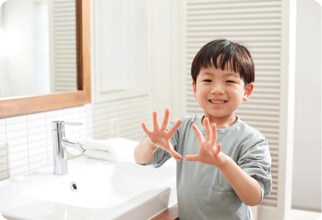 Child showing clean hands at modern bathroom sink with chrome faucet and white tile backsplash