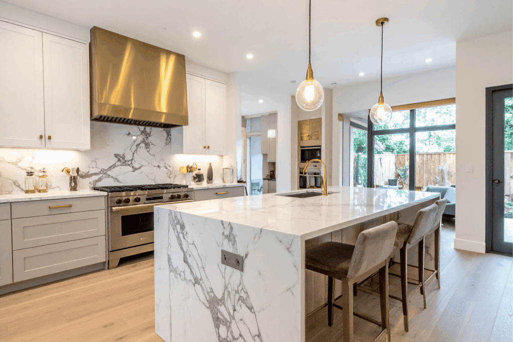 Modern luxury kitchen remodel with white shaker cabinets, marble countertops, and brass hardware by Pottstown Construction Company