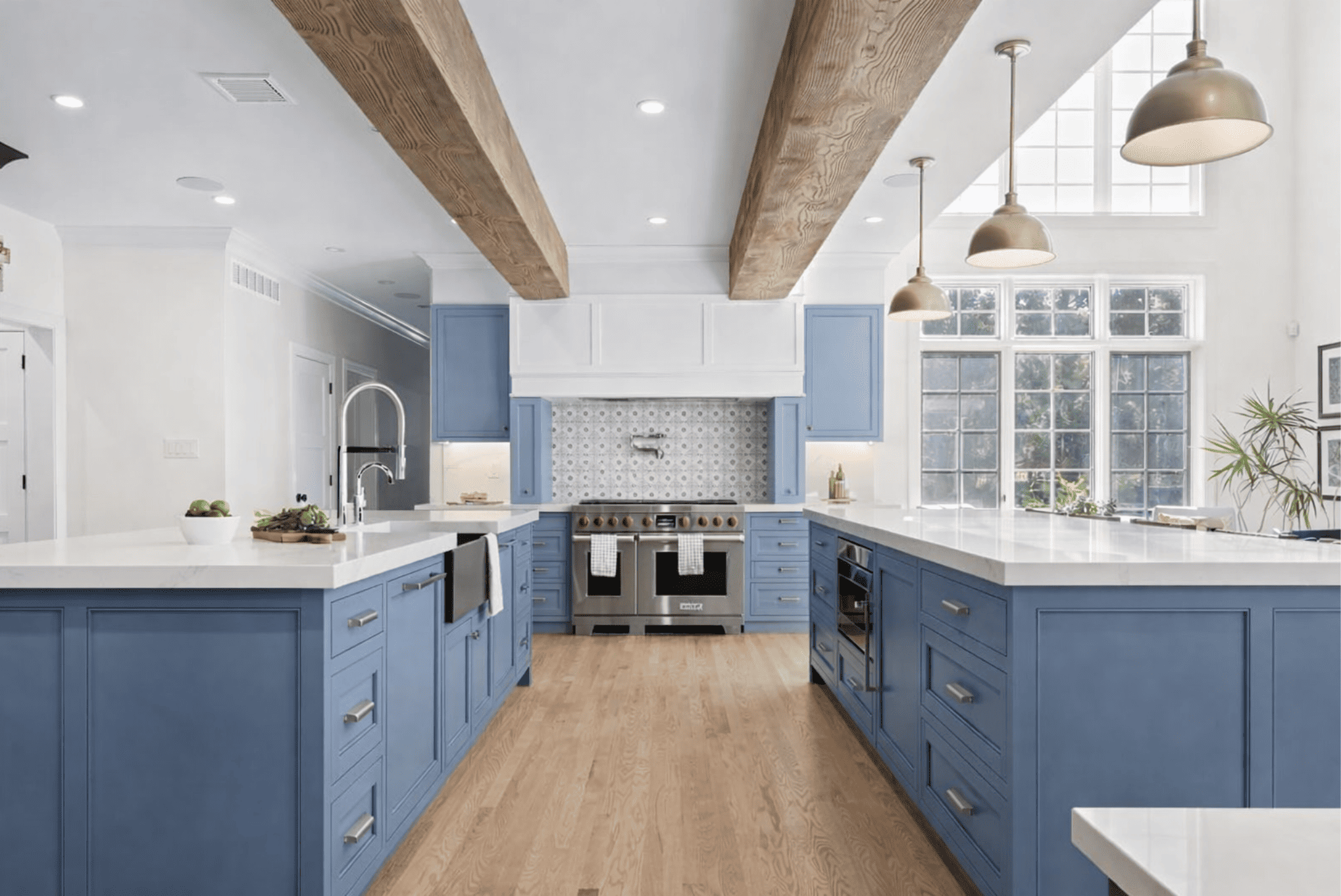 Blog 81 Modern kitchen remodel with blue shaker cabinets, white quartz countertops, exposed wood beams, and stainless steel appliances