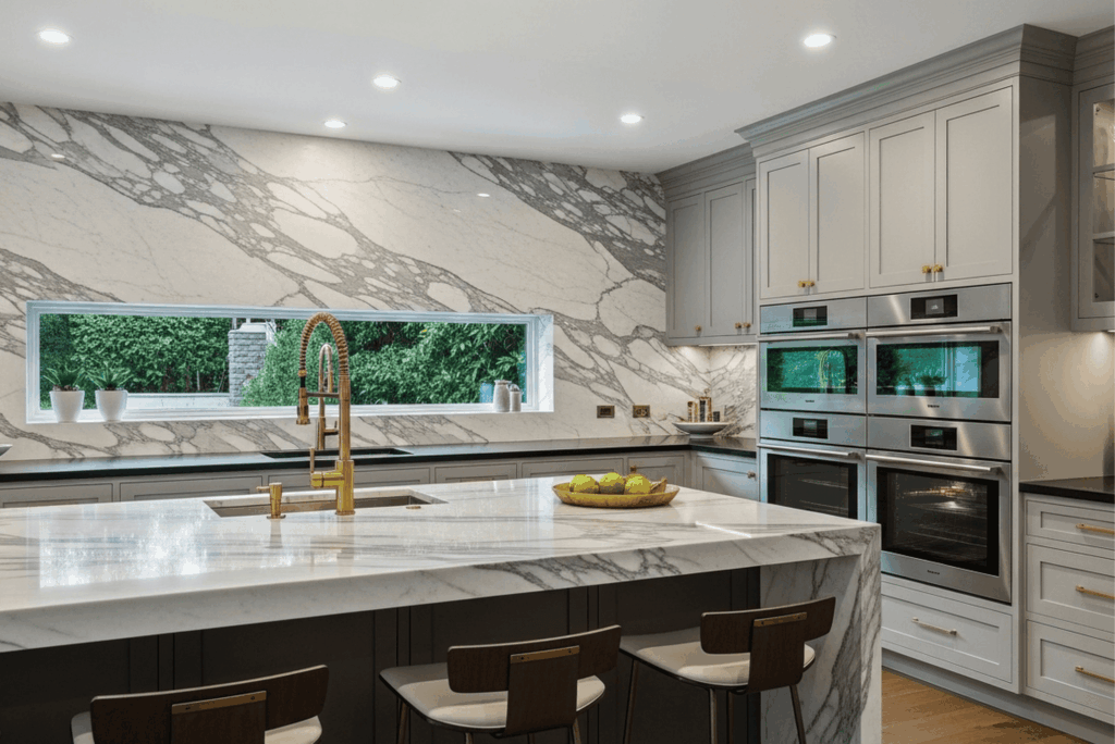 Modern luxury kitchen remodel with marble countertops, custom cabinetry, stainless steel appliances, and island seating