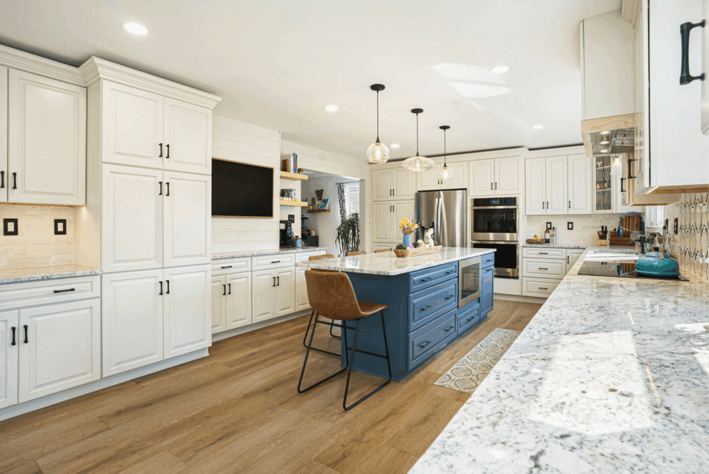 Modern kitchen remodel with white shaker cabinets, blue island, granite countertops, and stainless steel appliances