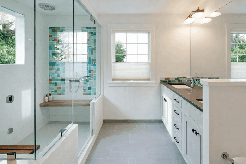 Modern master bathroom remodel with turquoise tile shower, white vanity, and frameless glass enclosure
