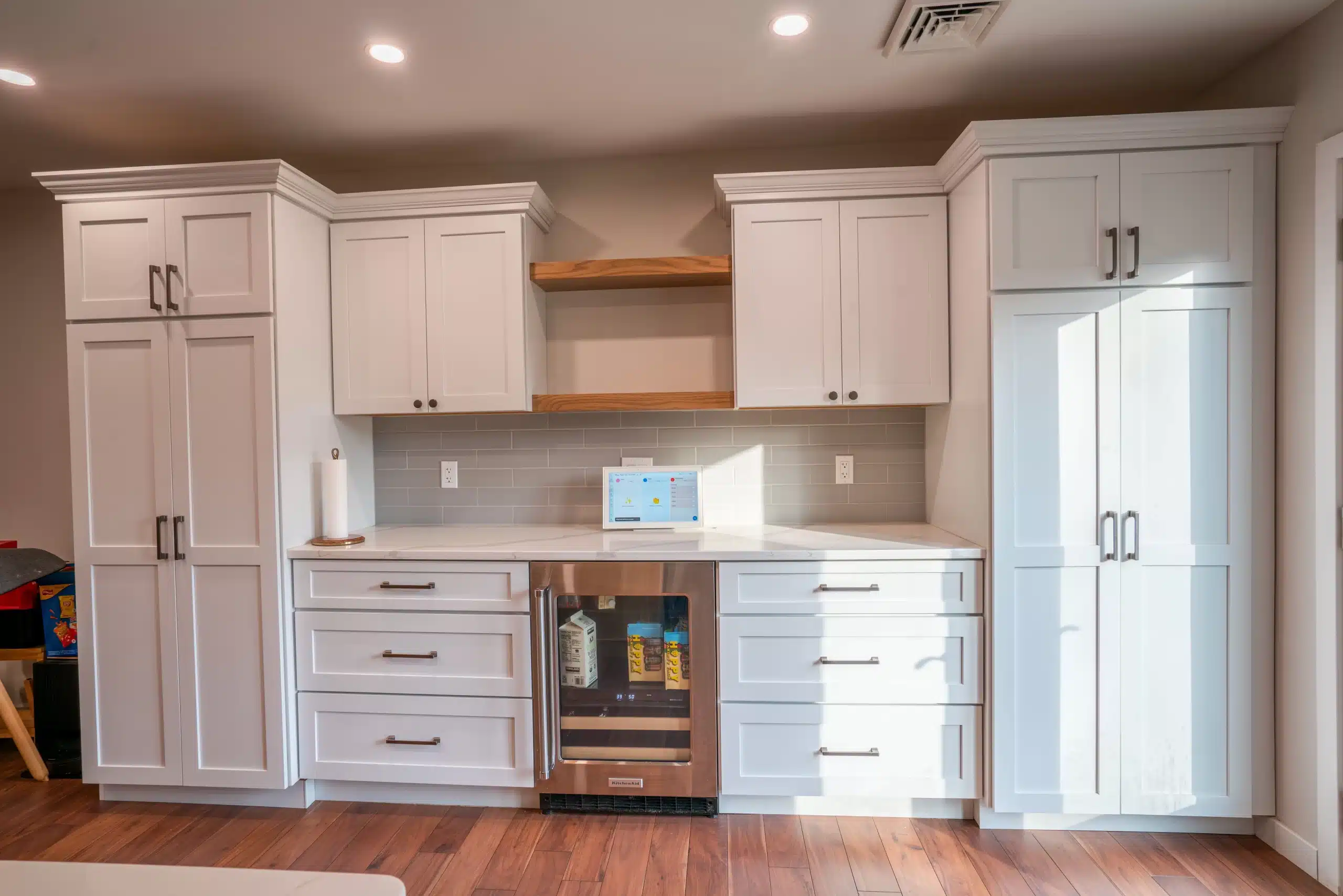 Custom white kitchen cabinets with quartz countertops and gray subway tile backsplash by Pottstown Construction Company