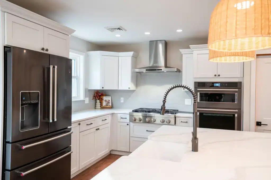 Modern kitchen remodel with white shaker cabinets, stainless steel appliances, quartz countertops, and gas range
