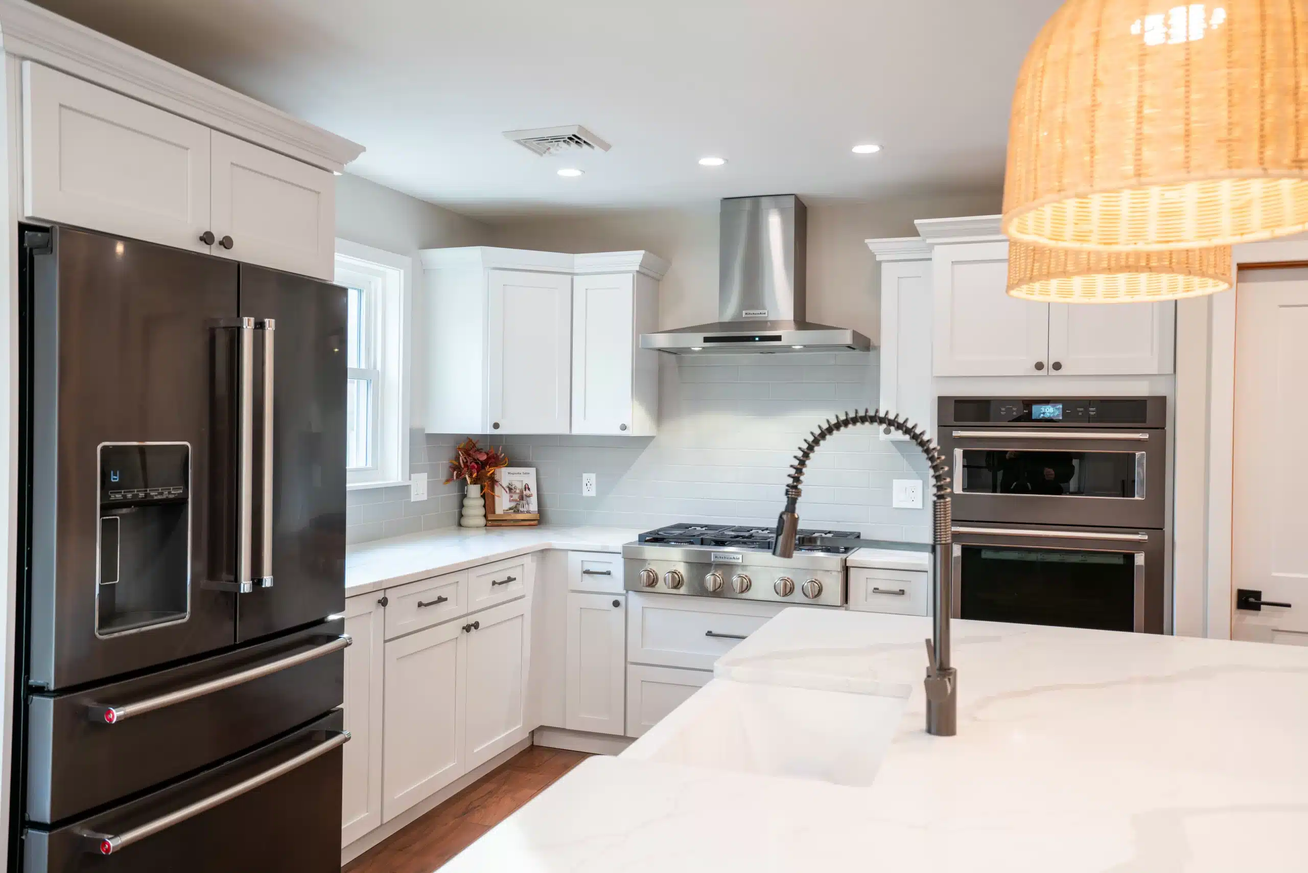 Modern kitchen remodel with white shaker cabinets, stainless steel appliances, quartz countertops, and gas range