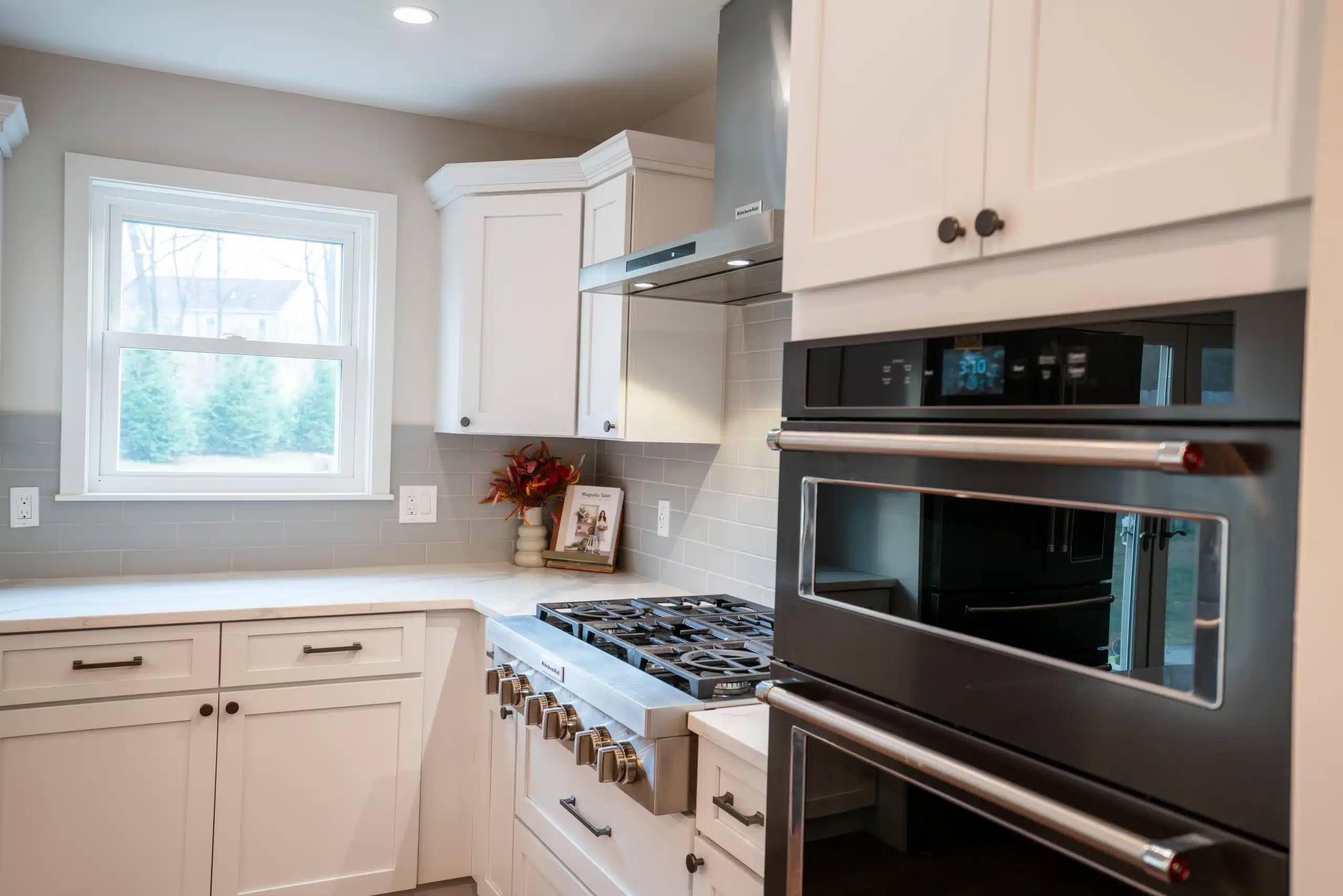 Modern kitchen remodel with cream shaker cabinets, quartz countertops, stainless steel appliances, and subway tile backsplash