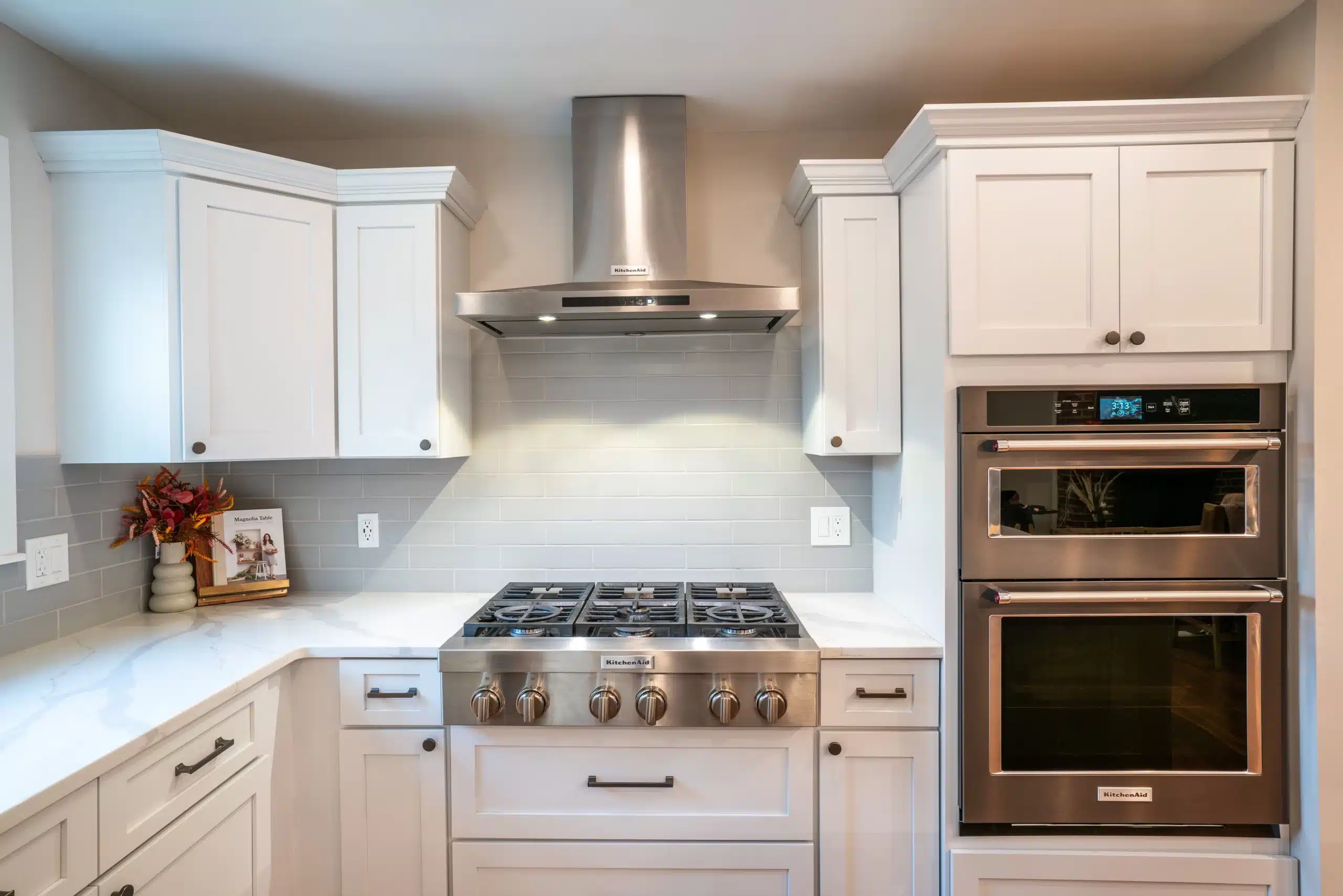 Modern white kitchen remodel with shaker cabinets, stainless steel appliances, and subway tile backsplash by Pottstown Construction