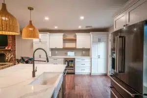 Modern kitchen remodel with white shaker cabinets, quartz countertops, stainless steel appliances, and hardwood flooring