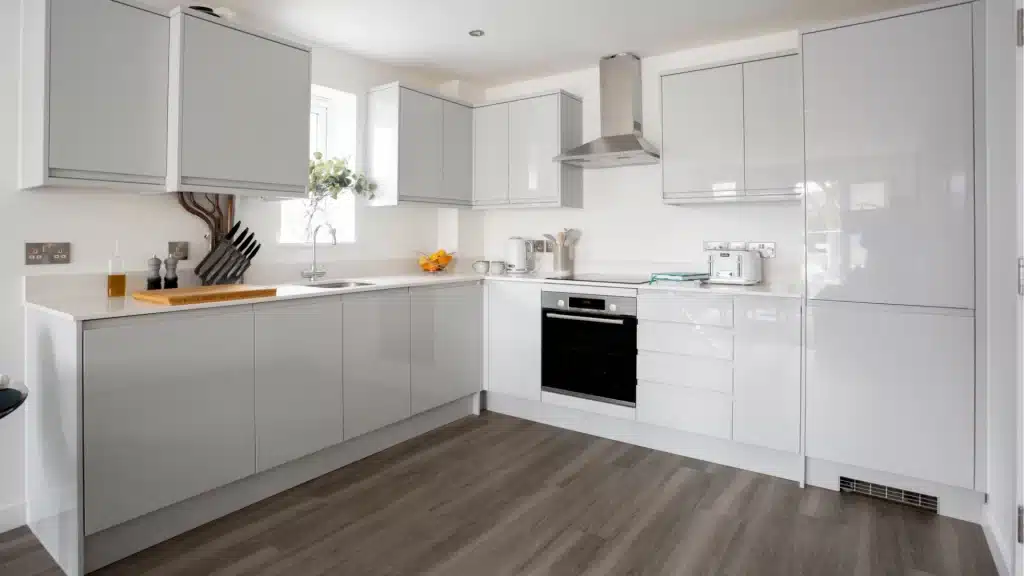 Modern white and gray kitchen remodel with custom cabinets, quartz countertops, and dark wood flooring by Pottstown Construction Company