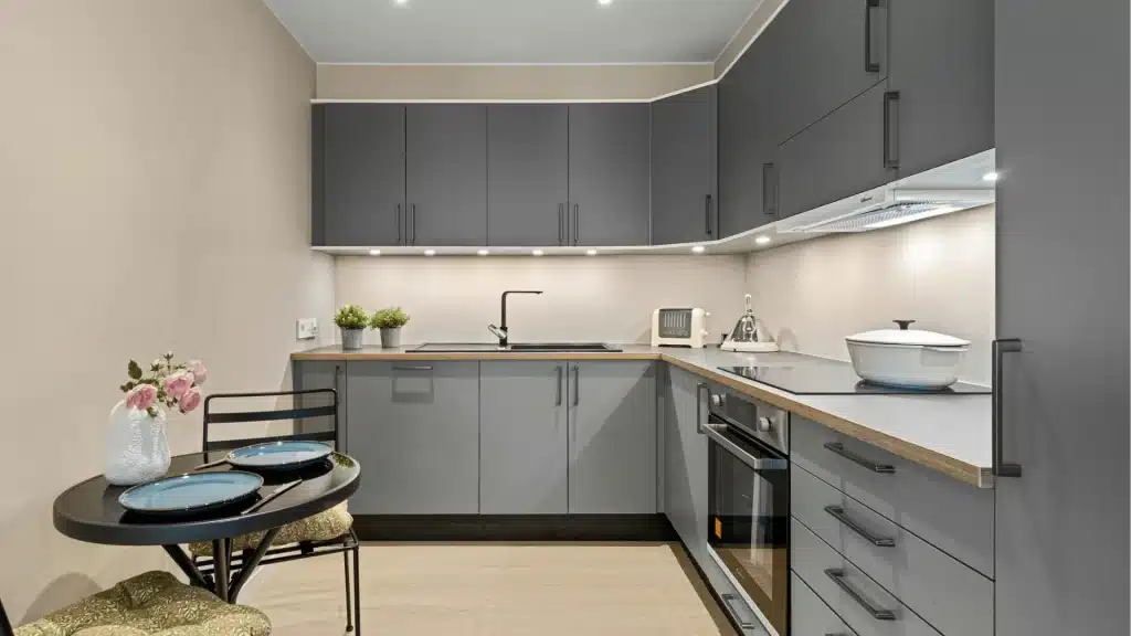 Modern gray kitchen remodel with wood countertops, black faucet, and recessed lighting by Pottstown Construction Company