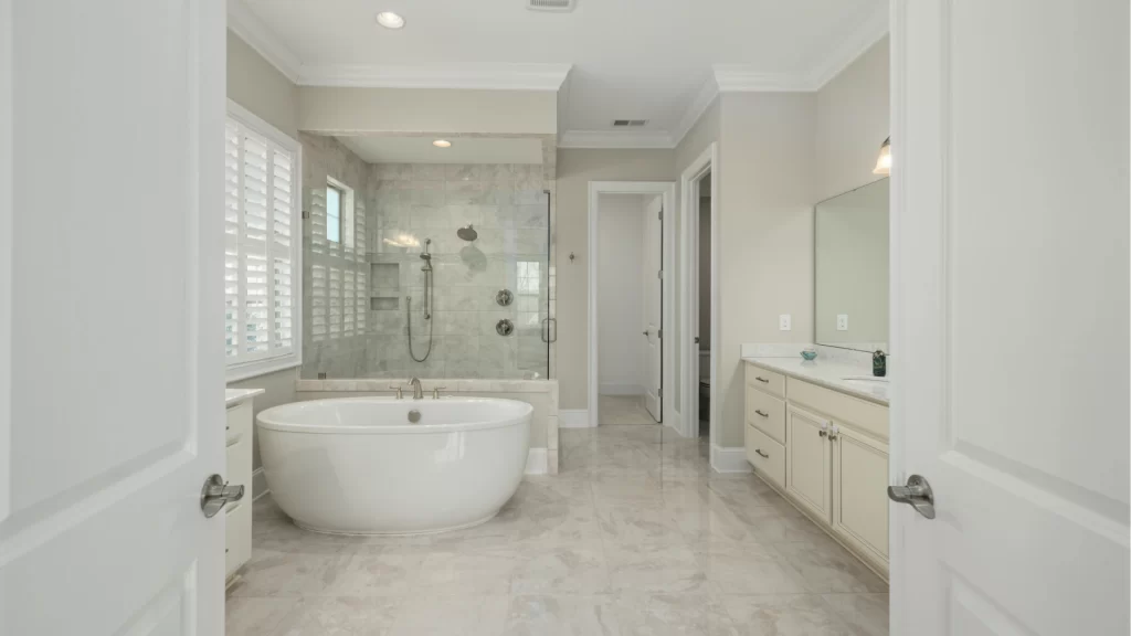 Luxury master bathroom remodel with freestanding soaking tub, marble tile, and glass-enclosed shower