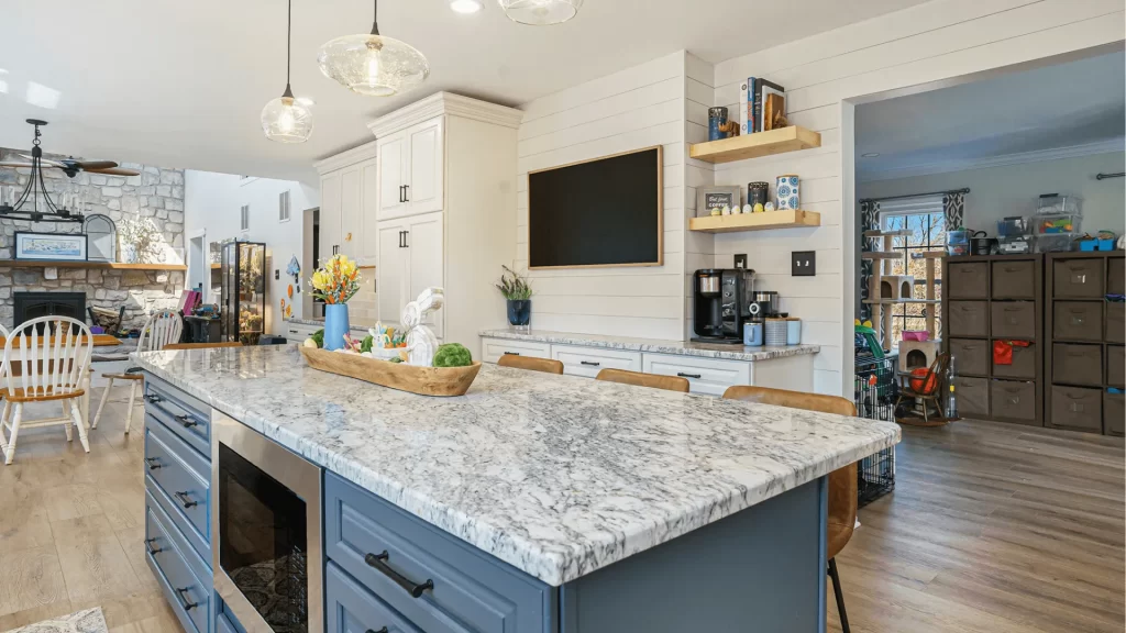 Modern kitchen renovation with white shaker cabinets, blue island, marble countertops, and open shelving by Pottstown Construction