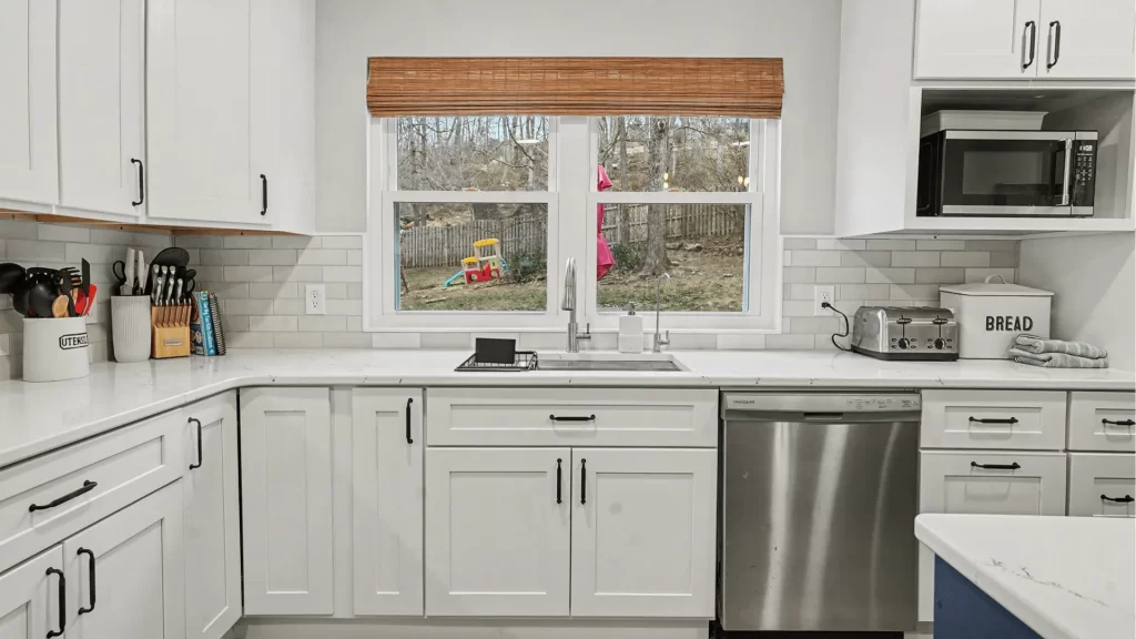 Modern white shaker kitchen remodel with quartz countertops, stainless steel appliances, and subway tile backsplash