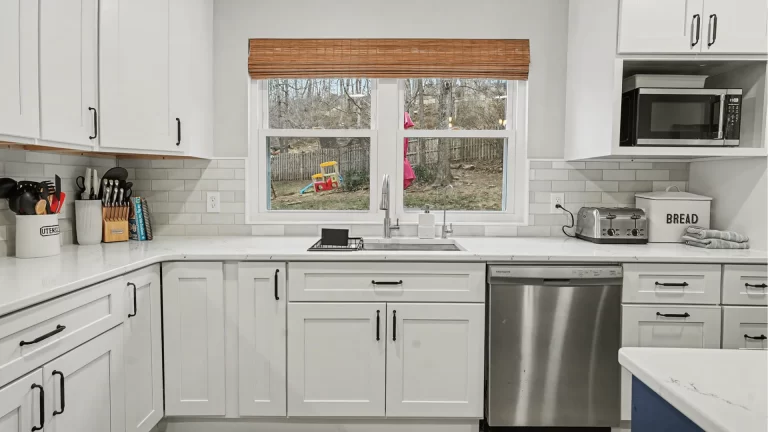 Modern white shaker kitchen remodel with quartz countertops, stainless steel appliances, and subway tile backsplash
