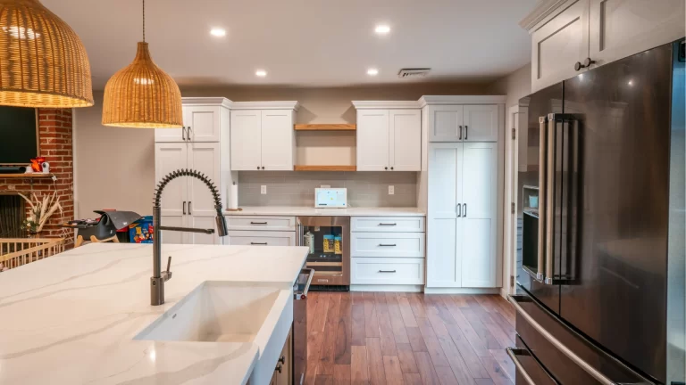 Modern kitchen remodel with white shaker cabinets, quartz countertops, stainless steel appliances, and wood flooring by Pottstown Construction Company