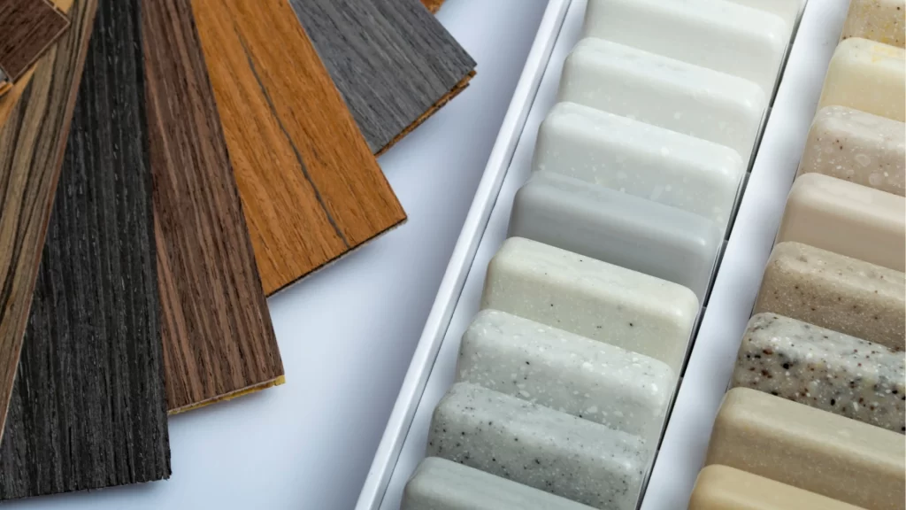 Flooring and countertop material samples including wood planks and quartz finishes for home renovation