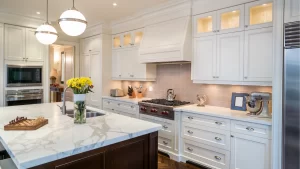 Elegant white kitchen with mixed cabinet finishes featuring cream upper cabinets, dark walnut island base, marble countertops, and stainless steel appliances