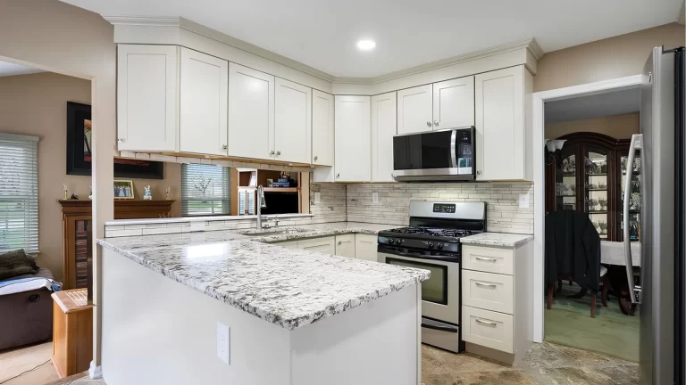 Modern white kitchen remodel with granite countertops, stainless steel appliances, and subway tile backsplash