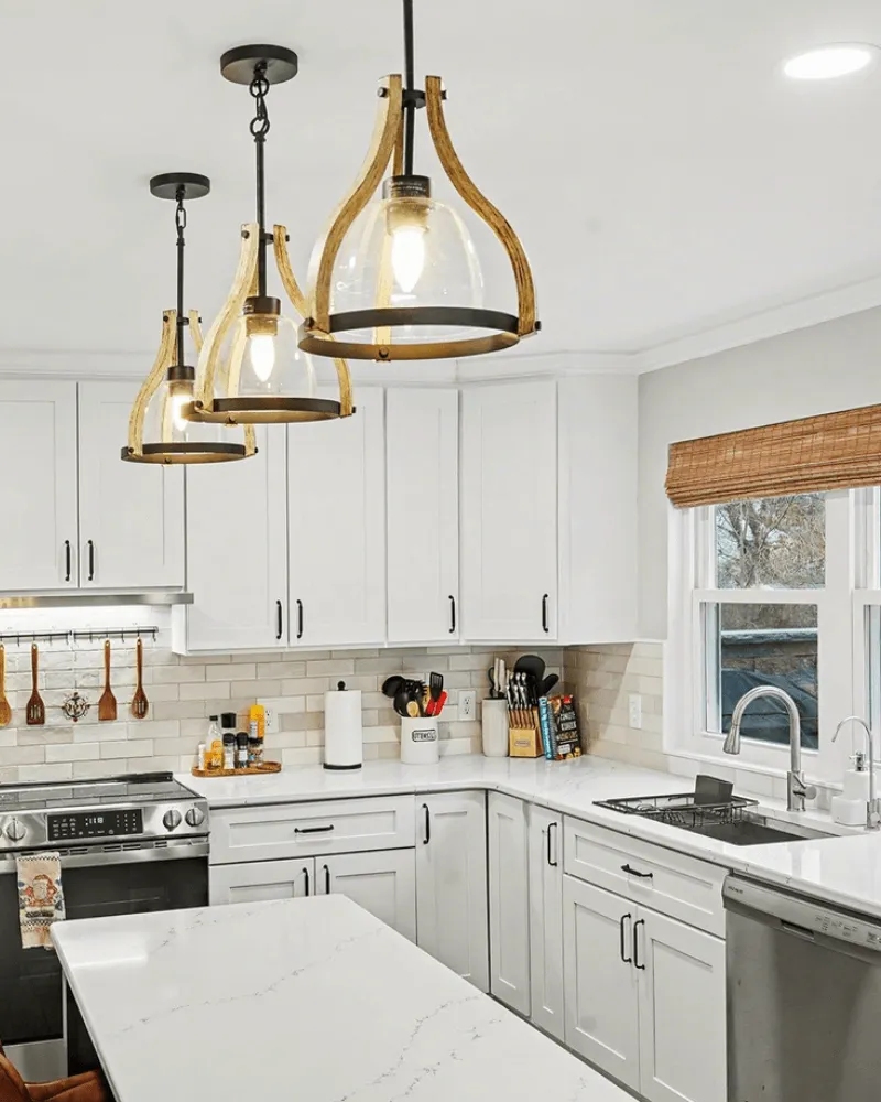 Modern white kitchen with shaker cabinets, quartz countertops, subway tile backsplash, and wood pendant lights