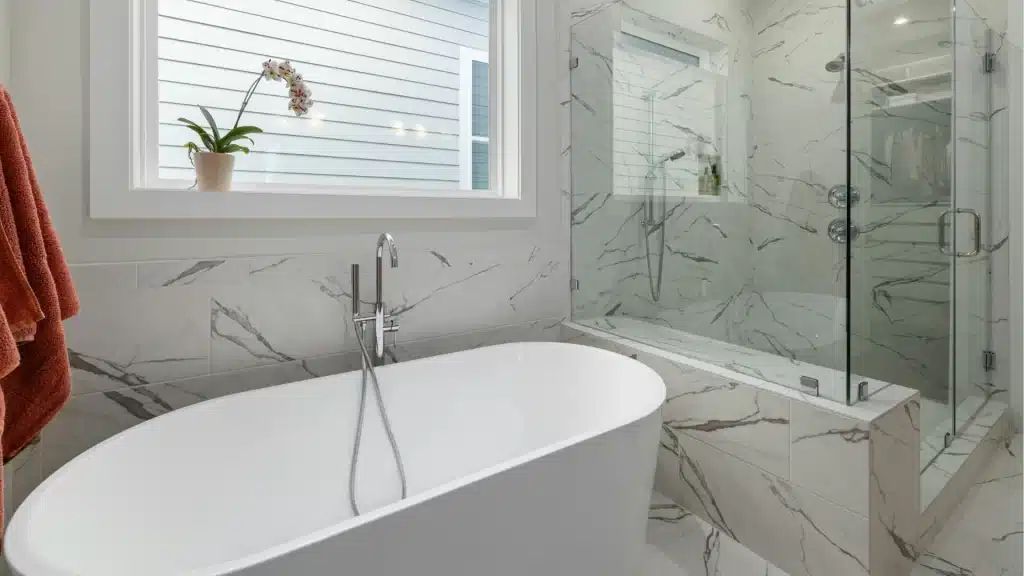 Marble bathroom with freestanding tub and glass enclosure