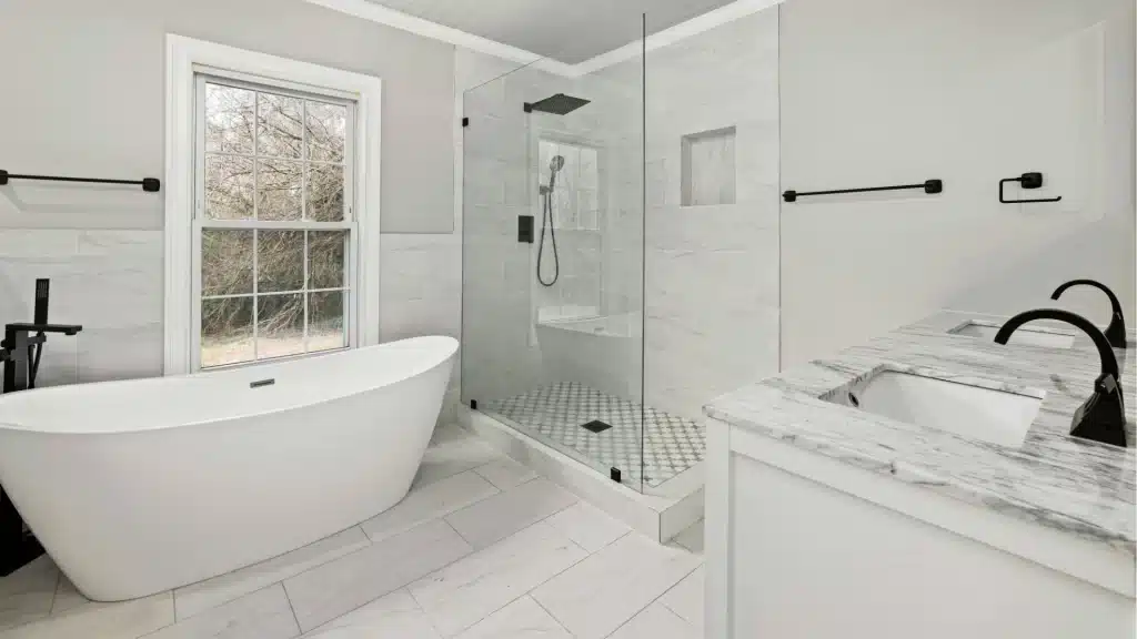 White bathroom with freestanding tub with walk in glass shower and grey double vanity