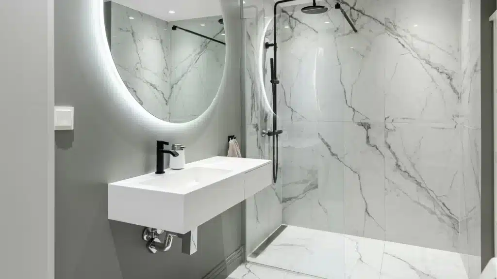 Modern bathroom remodel with marble tile shower, floating vanity, and LED mirror by Pottstown Construction