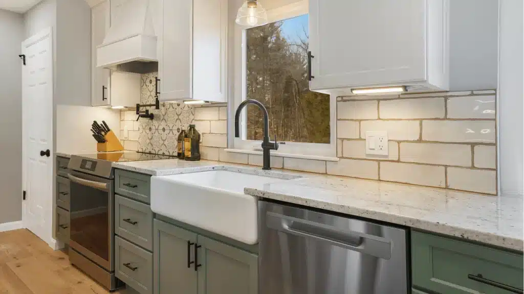 Modern kitchen remodel with green shaker cabinets, white farmhouse sink, subway tile backsplash, and quartz countertops