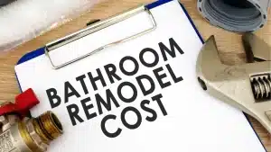 Bathroom remodel cost text on clipboard beside pipe fittings and wrench