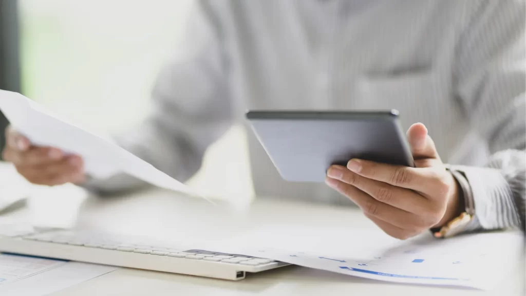 Person comparing bathroom remodeling estimates on a tablet and paperwork