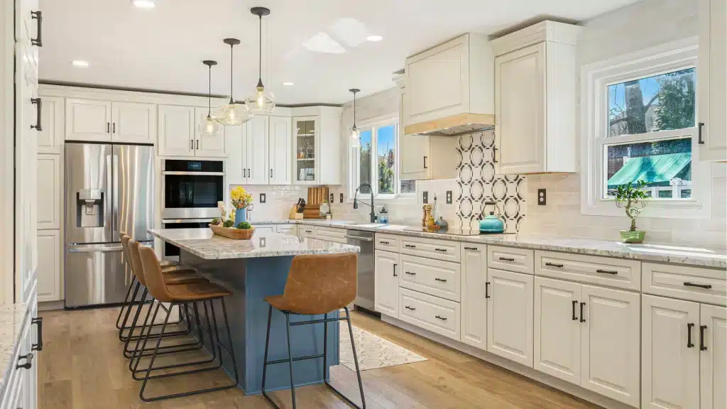 Modern kitchen remodel with white cabinetry, marble countertops, blue island, and stainless steel appliances