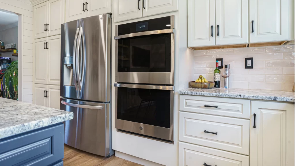 Modern kitchen remodel with white shaker cabinets, stainless steel appliances, and granite countertops