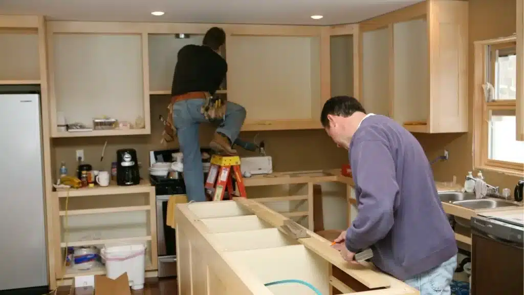 Contractors installing custom kitchen cabinets during home renovation project