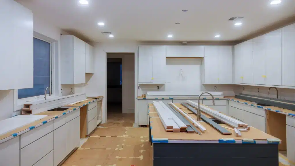 Modern kitchen remodel in progress with white cabinetry, island countertop, and recessed lighting installation by Pottstown Construction.