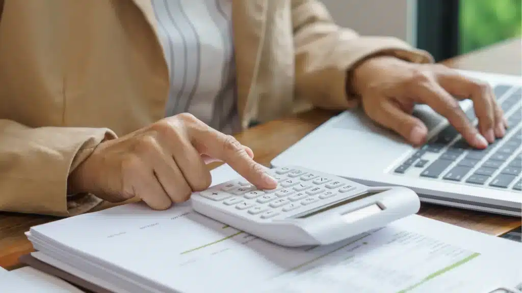Person using a calculator to estimate bathroom remodel costs