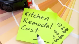 Kitchen remodel cost estimate note with paint color samples and construction planning tools on desk