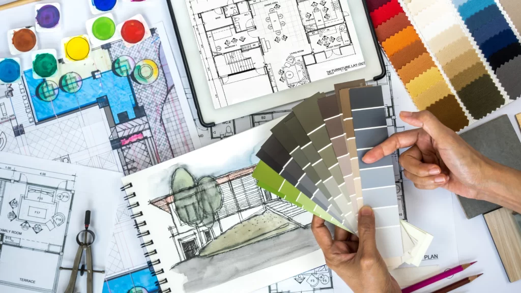 Interior design planning with construction blueprints, paint color swatches, and fabric samples for home renovation project