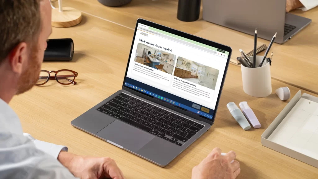 Man viewing Pottstown Construction Company website on laptop displaying kitchen and bathroom remodeling services