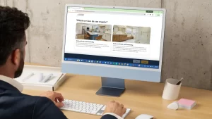 Man viewing Pottstown Construction Company website showing kitchen and bathroom remodeling services on desktop monitor